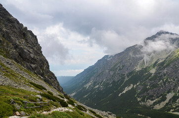 Naklejka na ściany i meble Mountain landscape in Slovakia, rocky mountain valley and climbing rocks with cloudy sky in the national park High Tatras