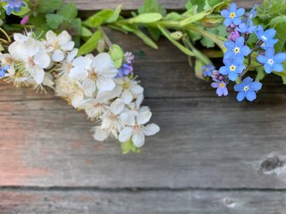 Bright blue forget-me-nots and white flowers on a wooden background. Copy space. Place for your text.
