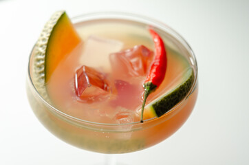 A holiday cocktail based on vodka, liqueur, fresh melon and red bird eye chilli, a refreshing drink prepared by a bartender