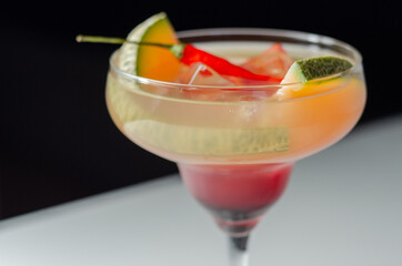 A holiday cocktail based on vodka, liqueur, fresh melon and red bird eye chilli, a refreshing drink prepared by a bartender