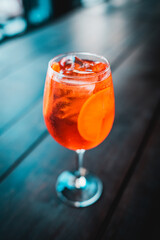Closeup glass of spritz aperol cocktail decorated with orange at bright bar counter background with...