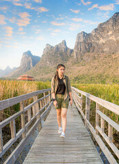 Freedom traveler woman standing with raised arms and enjoying a beautiful nature and cheering young woman backpacker at sunrise seaside mountain peak