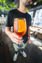 Closeup glass of spritz aperol cocktail decorated with orange at bright bar counter background with...