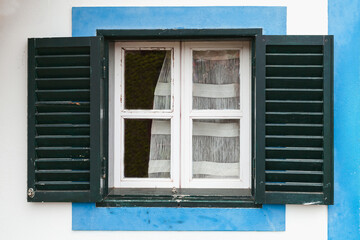 Window with open dark green shutters