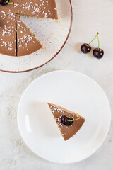 A slice of raw chocolate mousse cake with cherries. Sugar, gluten and lactose free. Vertical orientation, top view.