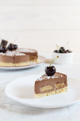 Slice of raw chocolate mousse cake with cherry and banana. Sugar, gluten and lactose free. Selective focus.