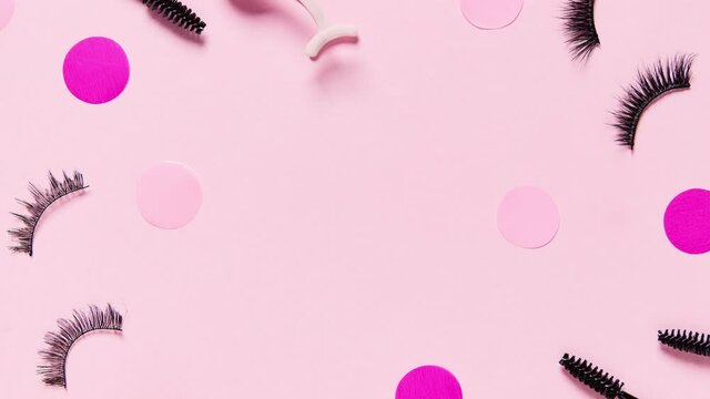 Stop motion 4k video with false eyelashes and accessories on pink background