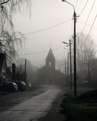 church in the fog gloomy old church in the morning mist on a city street