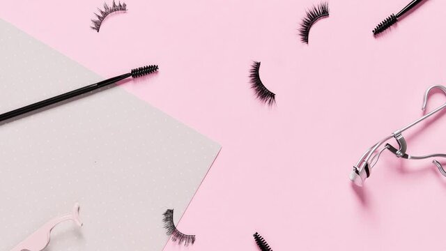 Stop motion 4k video with false eyelashes and accessories on pink background