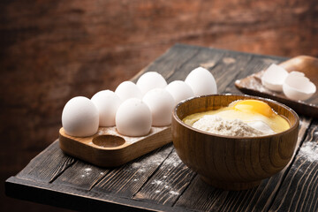 flour and eggs on a wooden table in country style