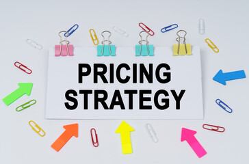 On the table there are paper clips and directional arrows, a sign that says - Pricing Strategy