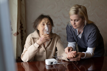 Young Female Doctor Holding Oxygen Mask Over Senior woman Patient's Face