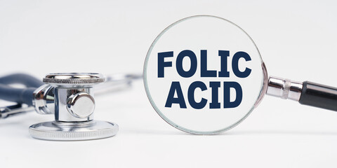 There is a stethoscope on the table, a magnifying glass with the inscription - FOLIC ACID