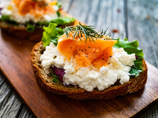 Breakfast - smoked salmon, cottage cheese and vegetables on wooden table
