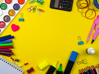 School supplies on a bright yellow background. Stationery on a yellow table. School concept. Back to school. Paints, pencils, rulers and other school items for study