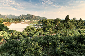 Scenery of tropical rainforest and historic railway on River Kwai in the evening at Kanchanaburi, Thailand