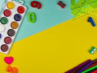 School supplies on a bright yellow and magenta background. Copy Space. Stationery on a yellow table. School concept. Back to school. Paints, pencils, rulers and other school items for study