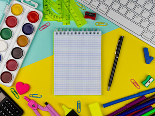 School supplies on a bright yellow and magenta background. Copy Space. Stationery on a yellow table. School concept. Back to school. Paints, pencils, rulers and other school items for study