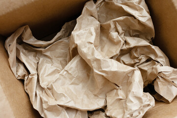 Crumpled yellow craft paper, brown cardboard box, white background, top view, cropped image, closeup