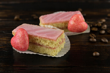 two sponge cakes in pink icing with a scattering of coffee beans