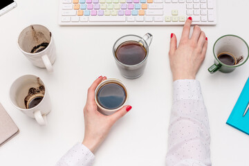 Office work concept, desk with coffee cups and other office attributed, woman working at the computer, female hands, top view, flat lay