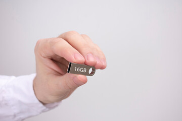 Man with USB flash drive, hand holding USB flash drive on a white background, copy space