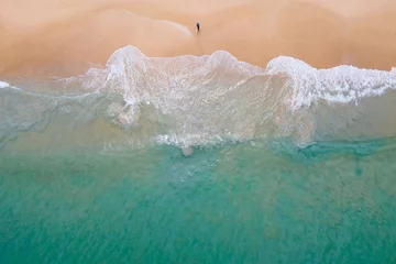 Fotobehang Aerial view of turquoise ocean wave reaching the coastline with lonely fisherman fishing on the beach. Beautiful tropical beach from top view. Andaman sea in Thailand. Summer holiday vacation concept © zephyr_p