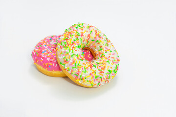 Two tasty donut with bright sprinkles, white background, side view, copy space