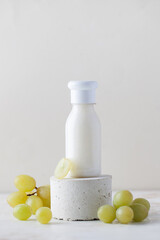 Grape cosmetics. A tube of cream, lotion for the skin of the face and body with grape extract on a pedestal. Copy space.