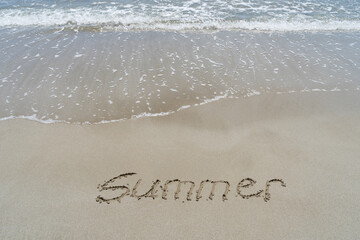 Fototapeta premium summer written in fine sand on the beach