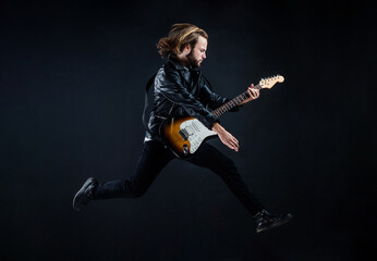 musician guitar player jumping. playing rock music. stylish crazy man. string musical instrument.