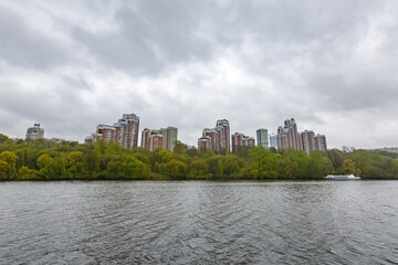 Fototapeta na wymiar Residential buildings on the banks of Moskva River on a cloudy day. Housing construction according to the city renovation program. Moscow, Russia