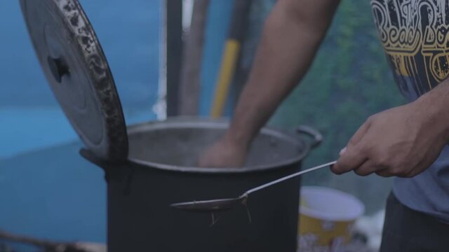 Closeup of Man taking corn out of a boiling pot