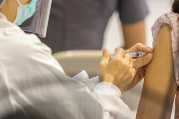 Doctor with face mask, holding syringe before make Covid-19 or coronavirus vaccine in hospital . Virus protection. COVID-2019 concept.