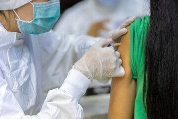 Doctor with face mask, holding syringe before make Covid-19 or coronavirus vaccine in hospital . Virus protection. COVID-2019 concept.
