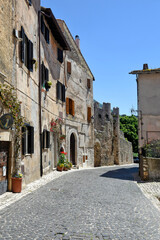 Sermoneta, Italy, 05/10/2021. A street between old medieval stone buildings in the historic town.