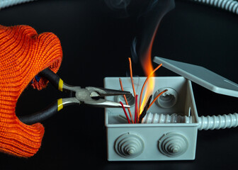 Short circuit in mains. The hands of master electrician close up or check during equipment repair