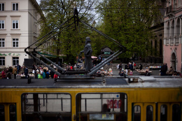 Yellow tram on the background of the monument to Ivan Fedorov and the spontaneous market of old books