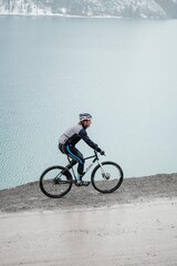 Fototapeta na wymiar person riding a bike above mountain lake