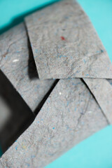 folded grey construction paper on cyan blue background