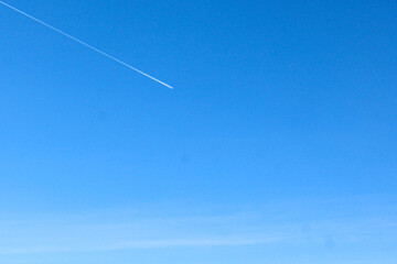 Clear blue sky with slightly visible plane exhaust . Idea for summer spring background 
