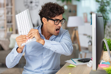 businessman slamming keyboard on the monitor
