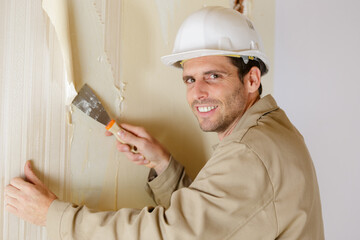a man removing the wallpaper