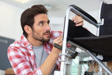 Fototapeta premium man repairing a wheelchair in his workshop