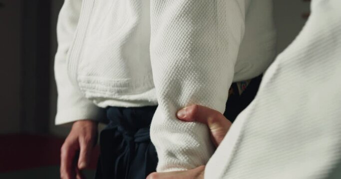 Cinematic close up of two budokai fighters practicing Aikido training in modern Japanese martial arts school.Concept of healthy lifestyle, sports and recreation, philosophy, defence, religious beliefs