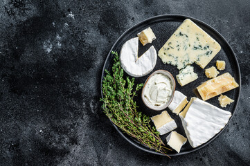 French Cheese plate. Camembert, Brie, Gorgonzola and blue cream cheese. Black background. Top view. Copy space