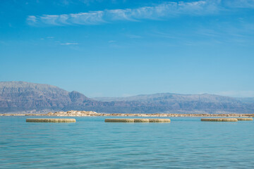 the Dead Sea coast in Israel, with salt mushrooms formations in the water, near to Ein Bokek resort, Israel