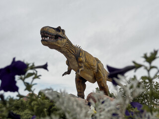 Low angle view to the T-Rex dinosaur in dino park against gray sky.