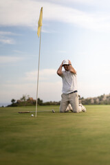 Obraz premium Angry golfer lamenting for missing his shot on the green a few inches from the hole.