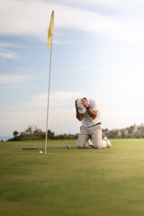 Obraz premium Angry golfer lamenting for missing his shot on the green a few inches from the hole.